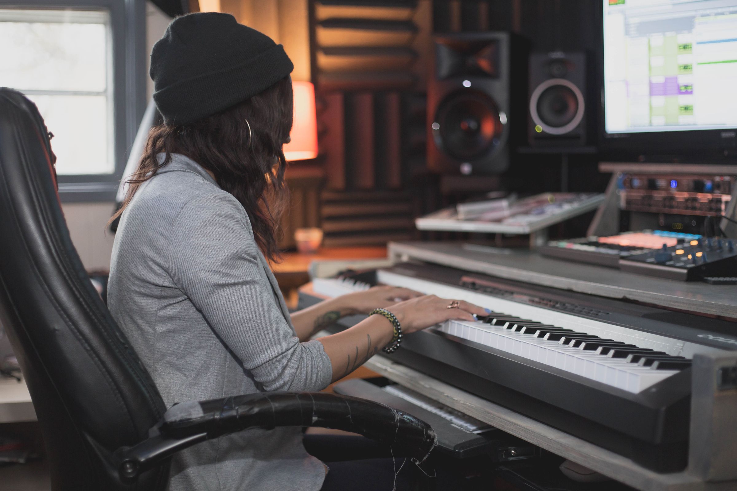 Musician working at a keyboard in a recording studio